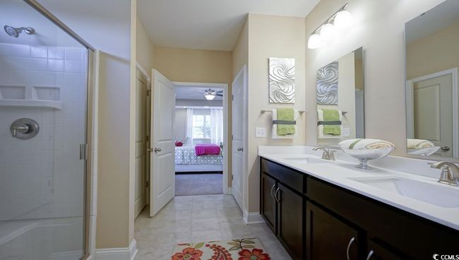 Ensuite bathroom featuring a shower with shower door, a ceiling fan, and double vanity | Image 26