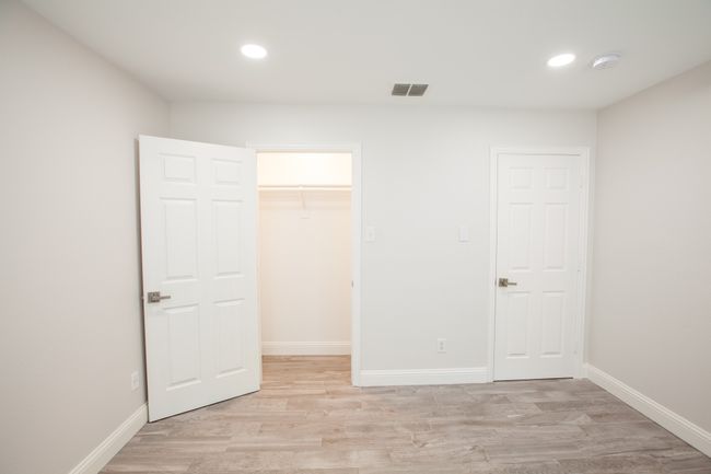 Unfurnished bedroom with light wood-style flooring, a walk in closet, recessed lighting, and a closet | Image 27