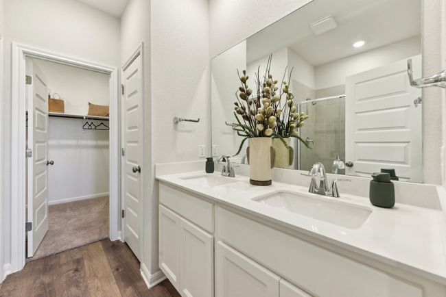 Bathroom with a stall shower, wood finished floors, a spacious closet, double vanity, and recessed lighting | Image 7