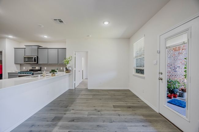 Kitchen with appliances with stainless steel finishes, gray cabinetry, light countertops, backsplash, and recessed lighting | Image 11