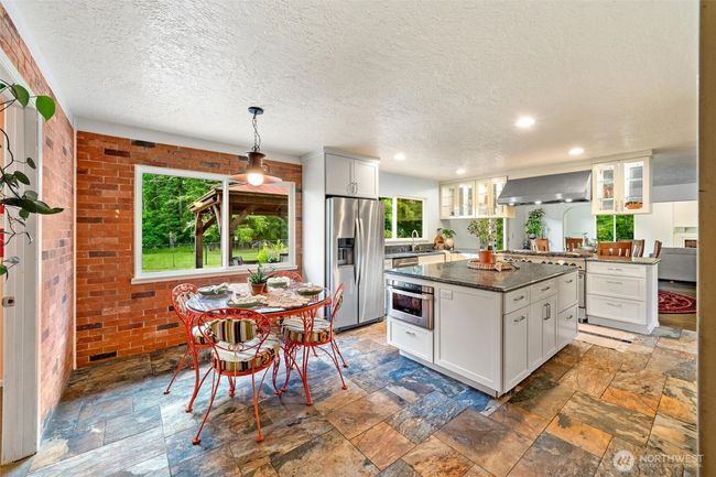 The kitchen windows span the views of the back forest bringing the lush green into the home. | Image 10