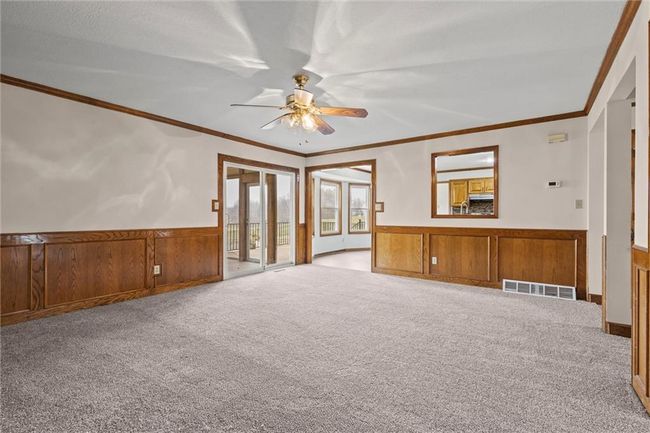 Unfurnished living room with light carpet, ceiling fan, and crown molding | Image 10