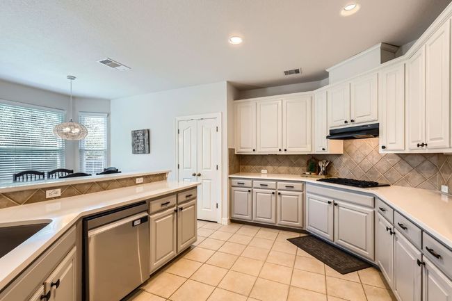 Kitchen with gas stovetop, light tile floor, and tasteful backsplash | Image 8
