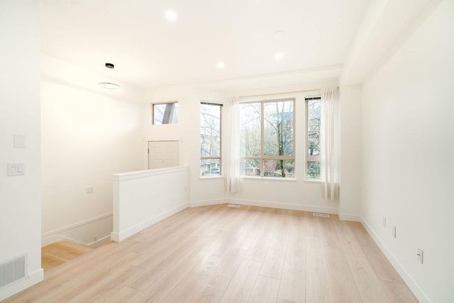 Spare room featuring baseboards, light wood-style floors, and visible vents | Image 12