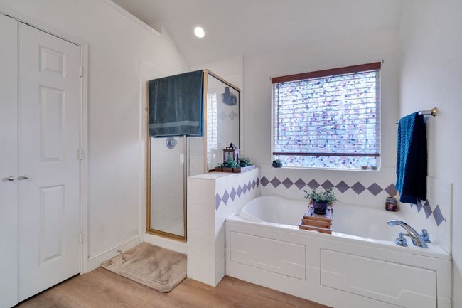 Bathroom featuring a shower stall, a bath, and wood finished floors | Image 30