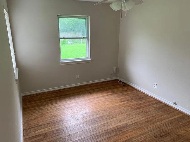Spare room with wood finished floors, a ceiling fan, and baseboards | Image 5