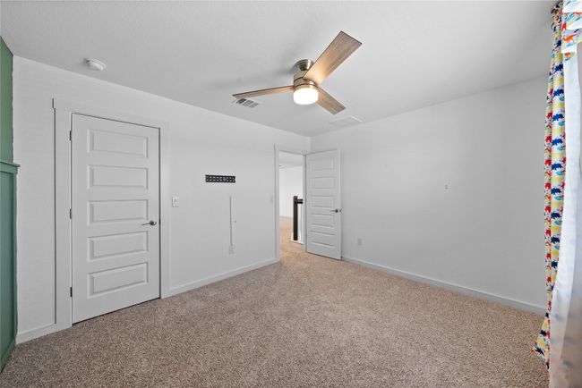 Unfurnished bedroom with a ceiling fan, carpet floors, baseboards, and visible vents | Image 27