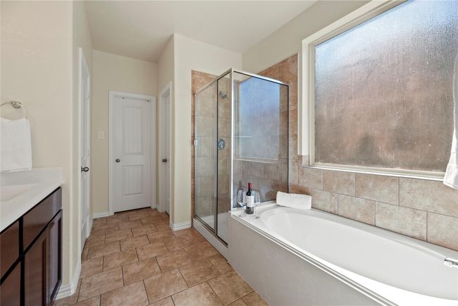 Every primary bedroom needs an en suite with class and sophistication! Delivering ample quantities of both, this spa-like sanctuary is well-equipped for the most glamourous of self-care routines. | Image 12
