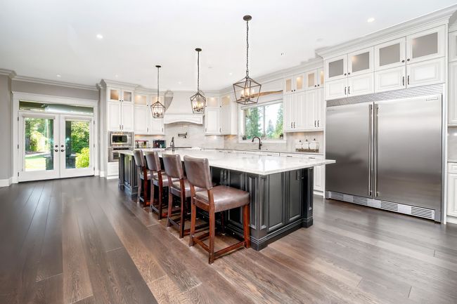Kitchen featuring built in appliances, white cabinetry, dark wood-style floors, and tasteful backsplash | Image 10
