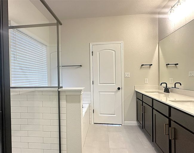 Full bath featuring tile flooring, double vanity, and a garden tub | Image 12