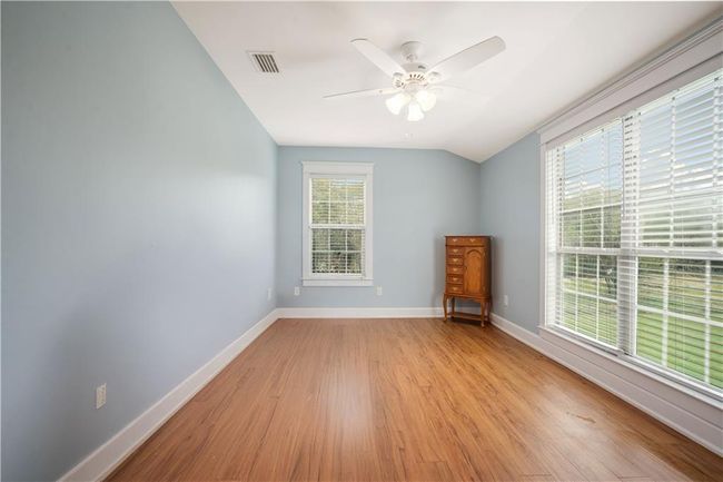 Spare room featuring baseboards, ceiling fan, vaulted ceiling, and light wood-type flooring | Image 25