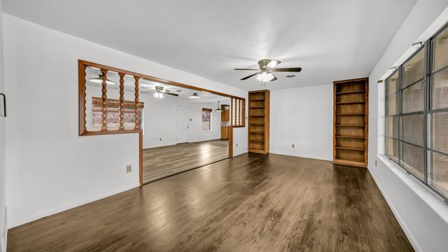 Front living room with ceiling fan, wood-style flooring, and built in shelving | Image 5