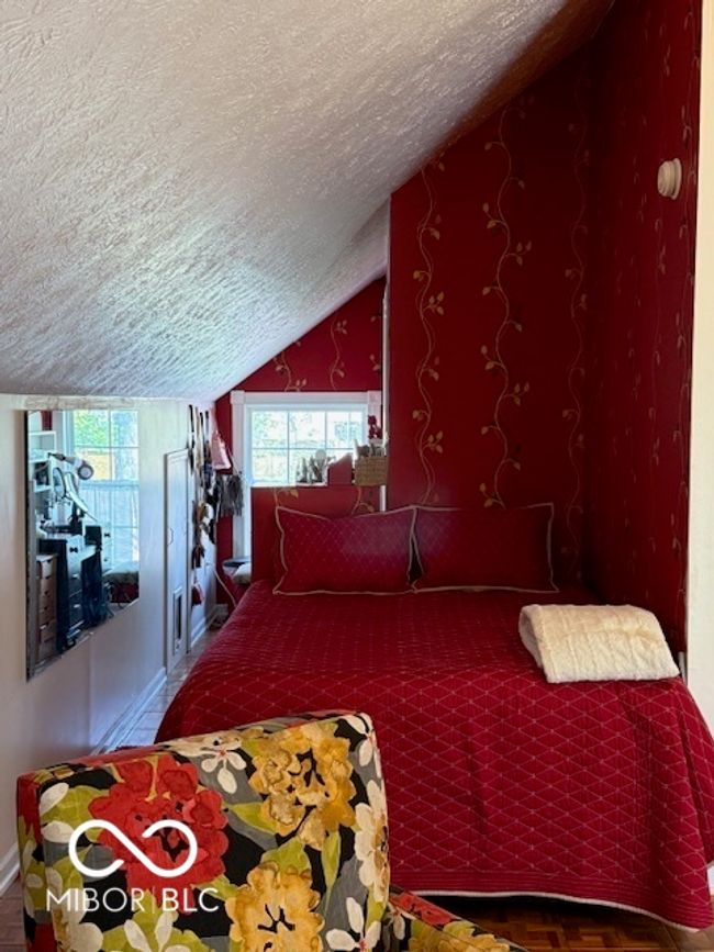 bedroom with baseboards, a textured ceiling, and lofted ceiling | Image 23