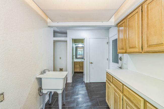 Clothes washing area featuring cabinet space and stone finish flooring | Image 18