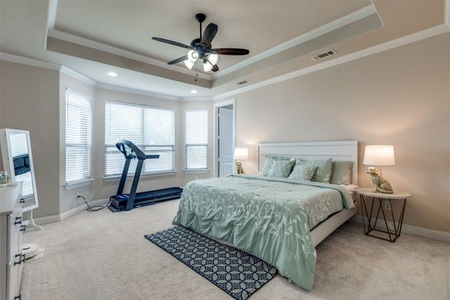 Bedroom featuring a tray ceiling, carpet flooring, ornamental molding, and ceiling fan | Image 22
