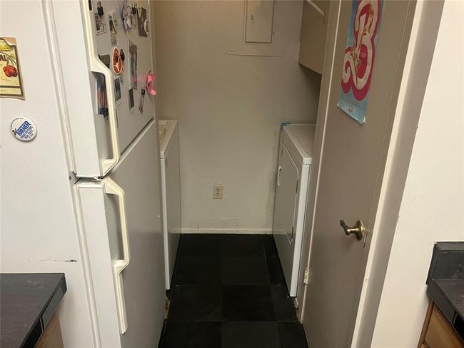 Washroom featuring washer / dryer, electric panel, and dark tile patterned floors | Image 7