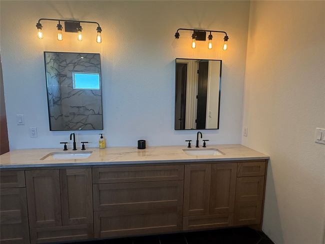 Bathroom featuring double vanity, a shower, and a textured wall | Image 16
