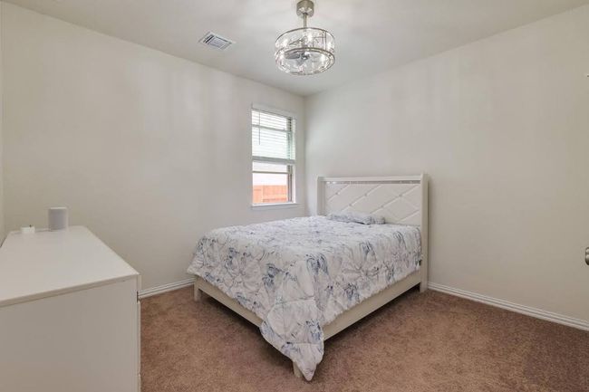 Carpeted bedroom featuring a chandelier and baseboards | Image 18