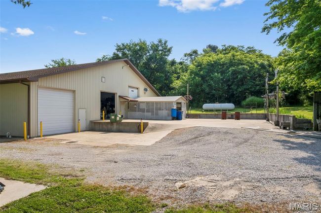 View of side of home featuring an outdoor structure and a garage | Image 16