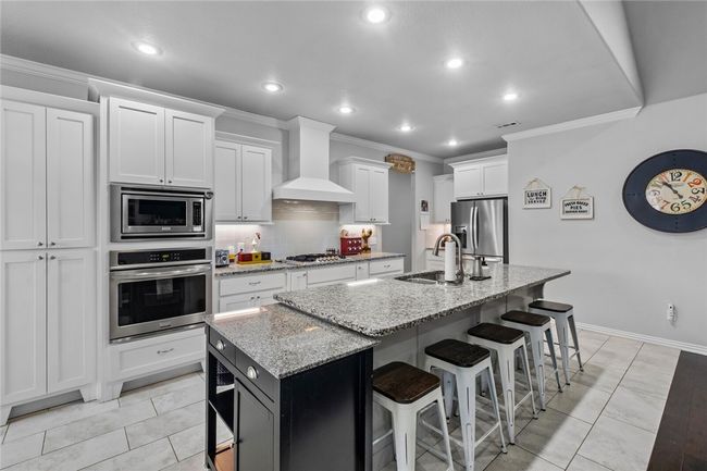 Very functional open kitchen with lots of countertop work space. Pantry to the left next to the ovens. | Image 10
