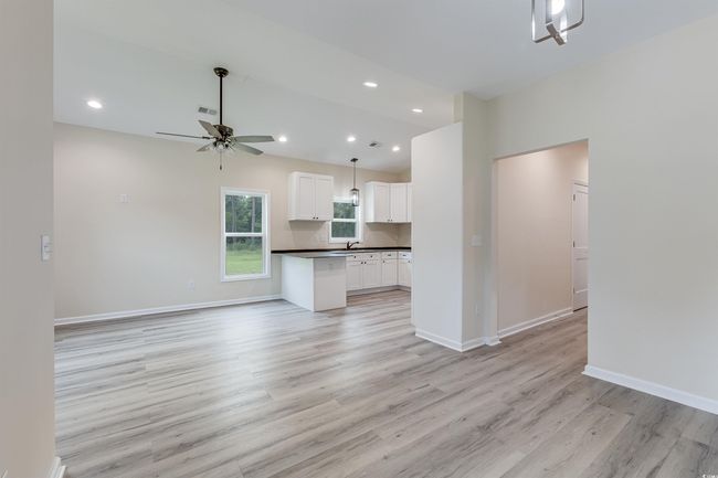Unfurnished living room with a ceiling fan, light wood-style flooring, a sink, recessed lighting, and baseboards | Image 5