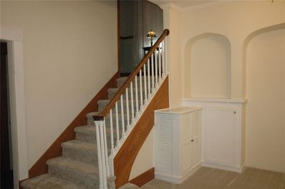 Staircase with crown molding and carpet flooring | Image 2