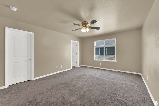 Empty room with a ceiling fan, carpet floors, and a smoke detector | Image 20