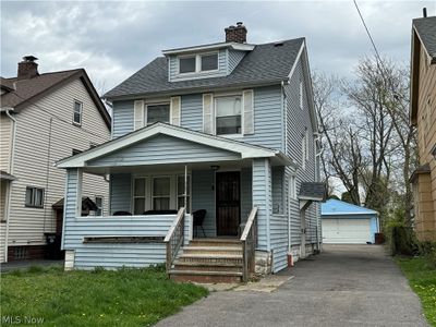 View of front of home with a garage, covered porch, and an outdoor structure | Image 1