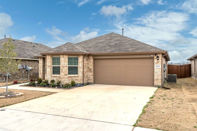 Ranch-style house featuring central AC unit, fence, an attached garage, concrete driveway, and brick siding | Image 31