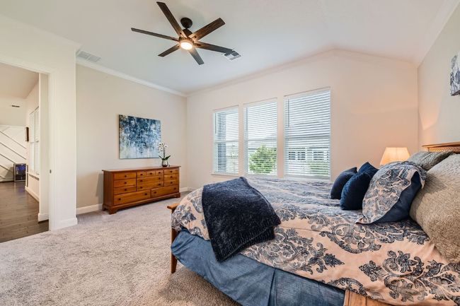Carpeted bedroom with ornamental molding, a ceiling fan, and vaulted ceiling | Image 16