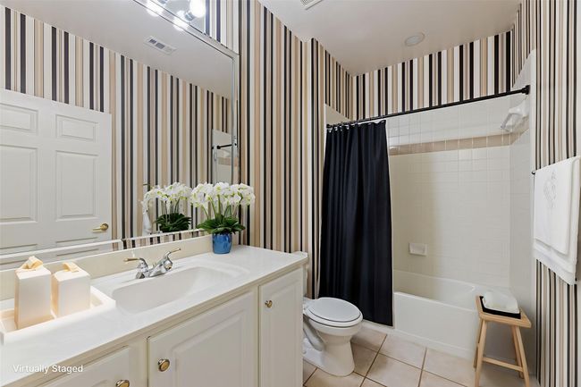 Full bath with wallpapered walls, vanity, tile patterned floors, and shower / tub combo | Image 34