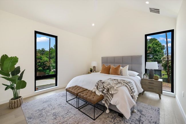 Bedroom featuring light wood finished floors, multiple windows, recessed lighting, high vaulted ceiling, and access to outside | Image 18