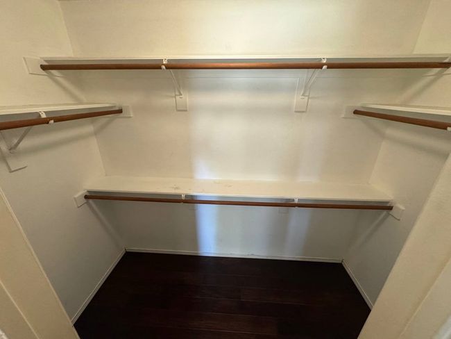 Spacious closet with dark wood-style flooring | Image 13