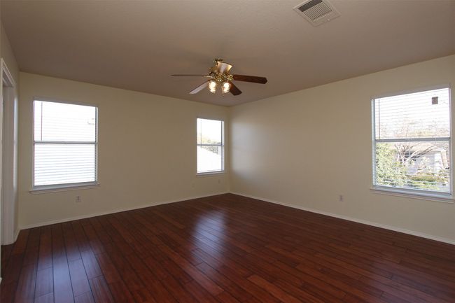 Empty room featuring ceiling fan and dark wood-type flooring | Image 12