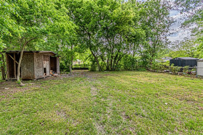 View of yard featuring fence, an outbuilding, and a storage shed | Image 25