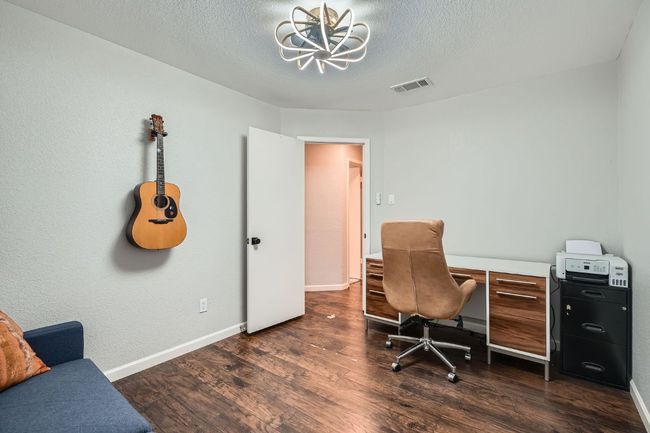 Office space with a chandelier, dark wood-style flooring, and a textured ceiling | Image 22