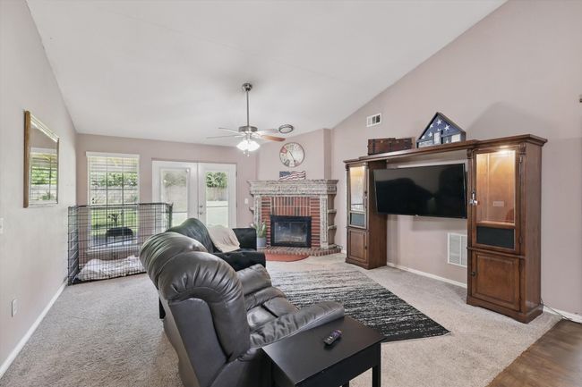 Living area with vaulted ceiling, a ceiling fan, visible vents, and baseboards | Image 9