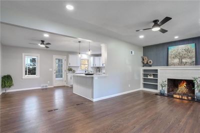 Beautiful living room and dining room area featuring ceiling fan, dark hardwood / wood-style flooring, and island so you can add bar stools. Leads out to a screened in porch. | Image 2