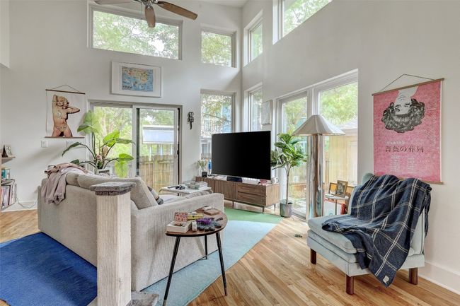 Living area with a wealth of natural light, a ceiling fan, wood finished floors, and a towering ceiling | Image 29