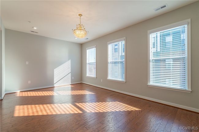 Unfurnished room with dark hardwood / wood-style floors and a notable chandelier | Image 9