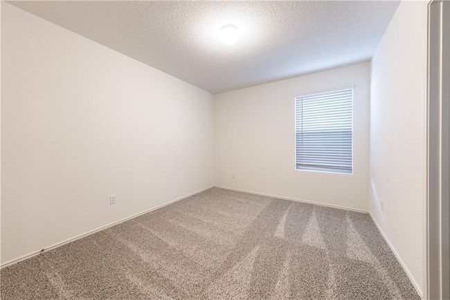Carpeted empty room featuring a textured ceiling and baseboards | Image 16