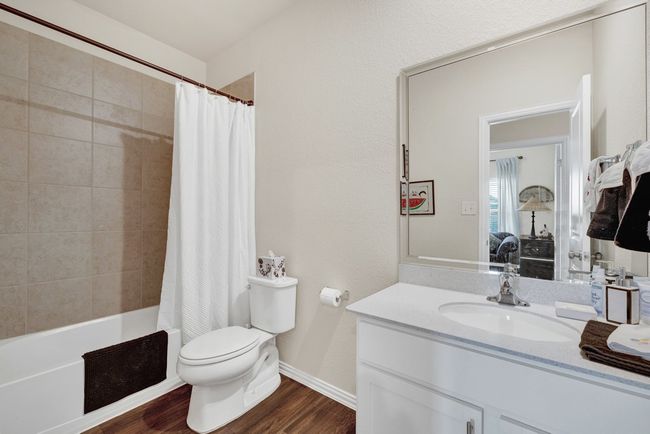 Bathroom featuring vanity, baseboards, toilet, visible vents, and wood finished floors | Image 5