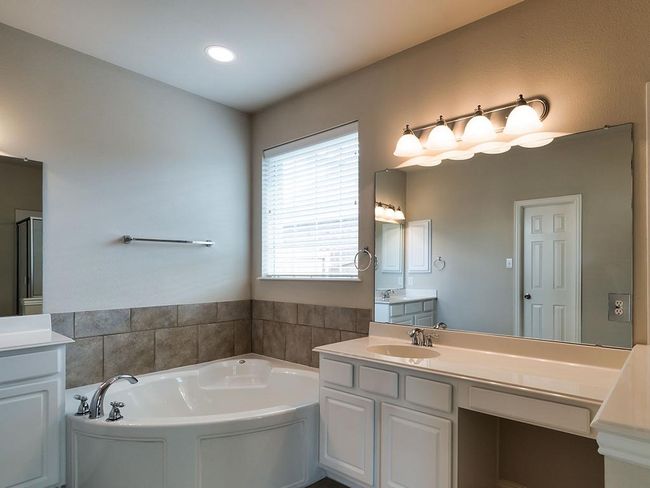 Bathroom with a garden tub, vanity, and a shower with shower door | Image 30