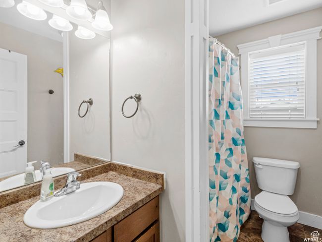 Bathroom featuring vanity, toilet, and a shower with curtain | Image 10