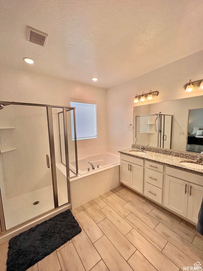 Bathroom featuring vanity, a textured ceiling, and plus walk in shower | Image 9