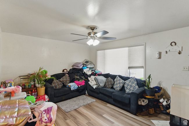 Living room with ceiling fan and light wood-style floors | Image 19