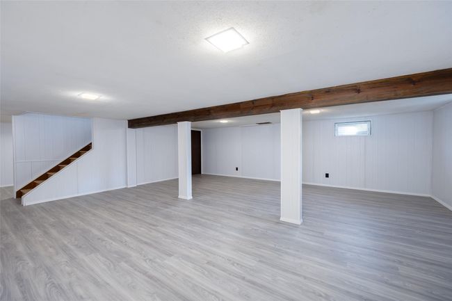 Basement featuring baseboards, wood finished floors, and stairs | Image 33