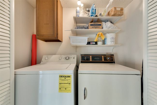 Laundry room featuring cabinets, independent washer and dryer, and a textured ceiling | Image 17