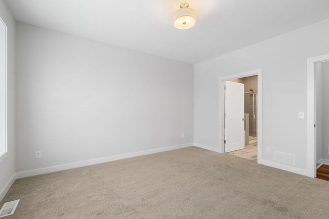 The master bedroom hosts plenty of space for a seating area and elegant finishes throughout, offering the perfect blend of comfort and style. | Image 22