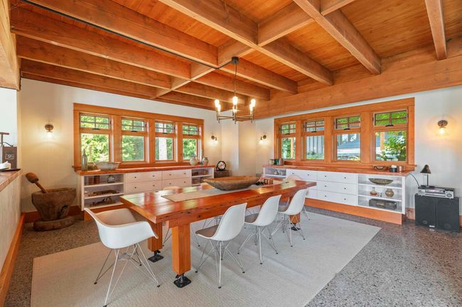 Dining room featuring wooden ceiling with exposed beams, speckle patterned floor, and a chandelier | Image 10